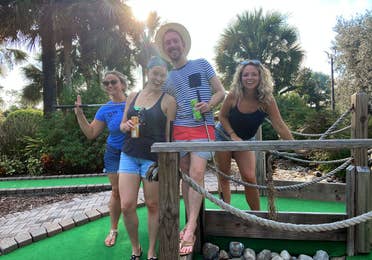 Featured Contributor, Angie Orth (far-right), and her friends hold their putters outside on our mini-golf course.