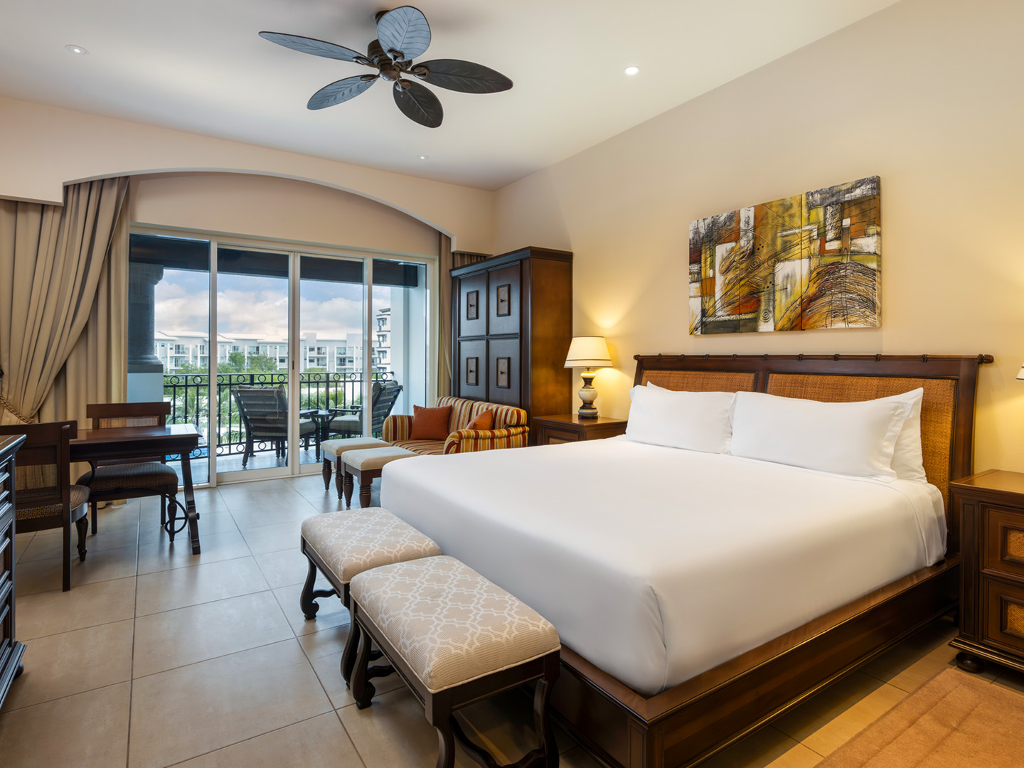 Master suite bedroom with king bed, balcony, and sitting area.