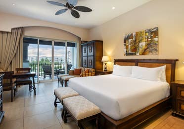 Master suite bedroom with king bed, balcony, and sitting area.