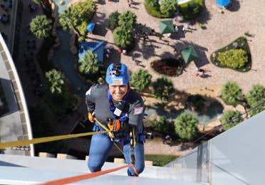 Woman repelling down the side of a building.