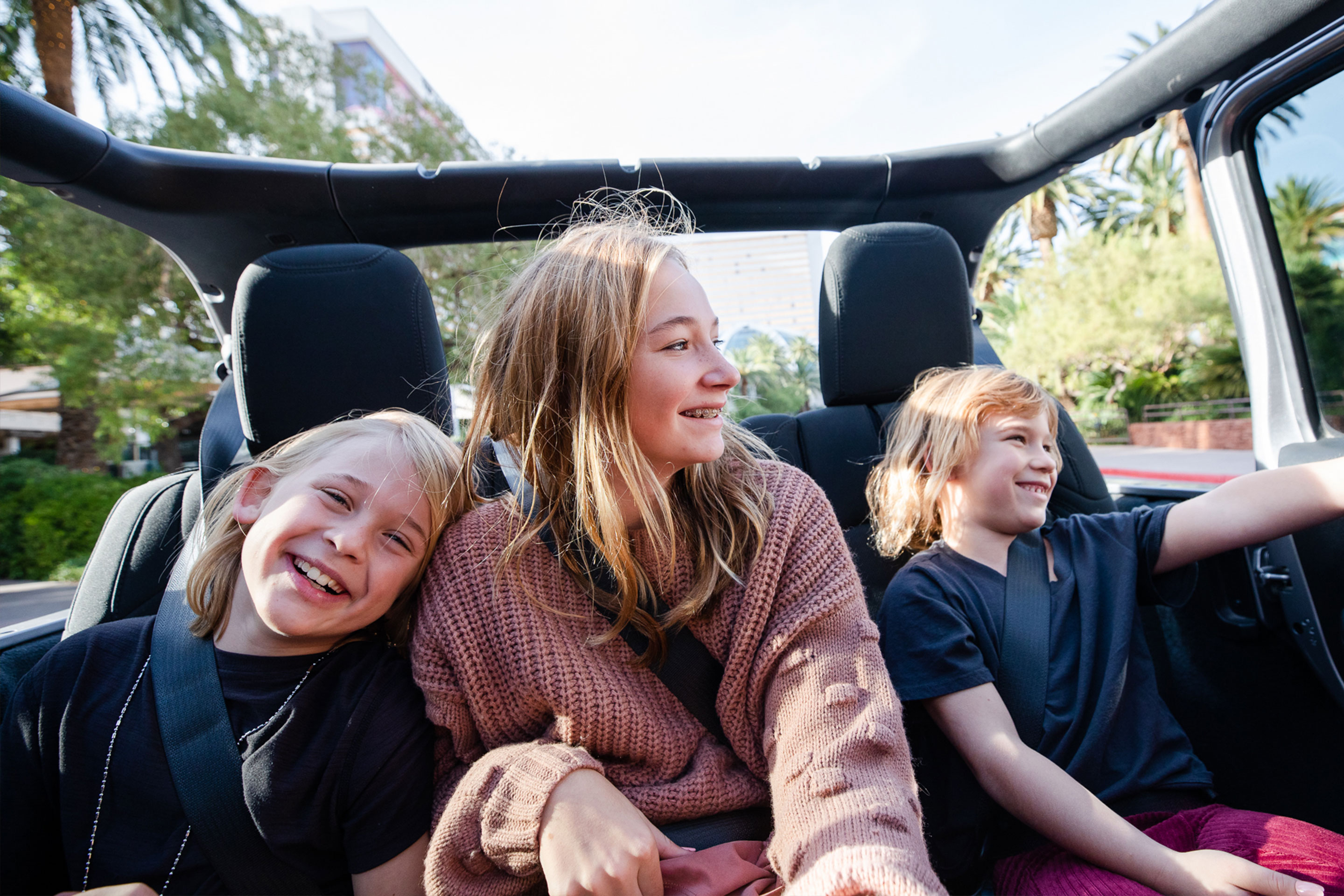 The Haby kids riding in the backseat of an open-top Jeep down the Vegas strip.