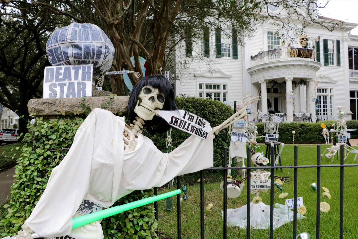 A group of fake skeletons placed in a front yard.