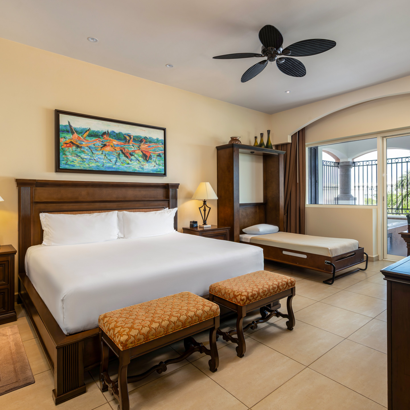 Spacious master bedroom with king bed, daybed, and balcony.