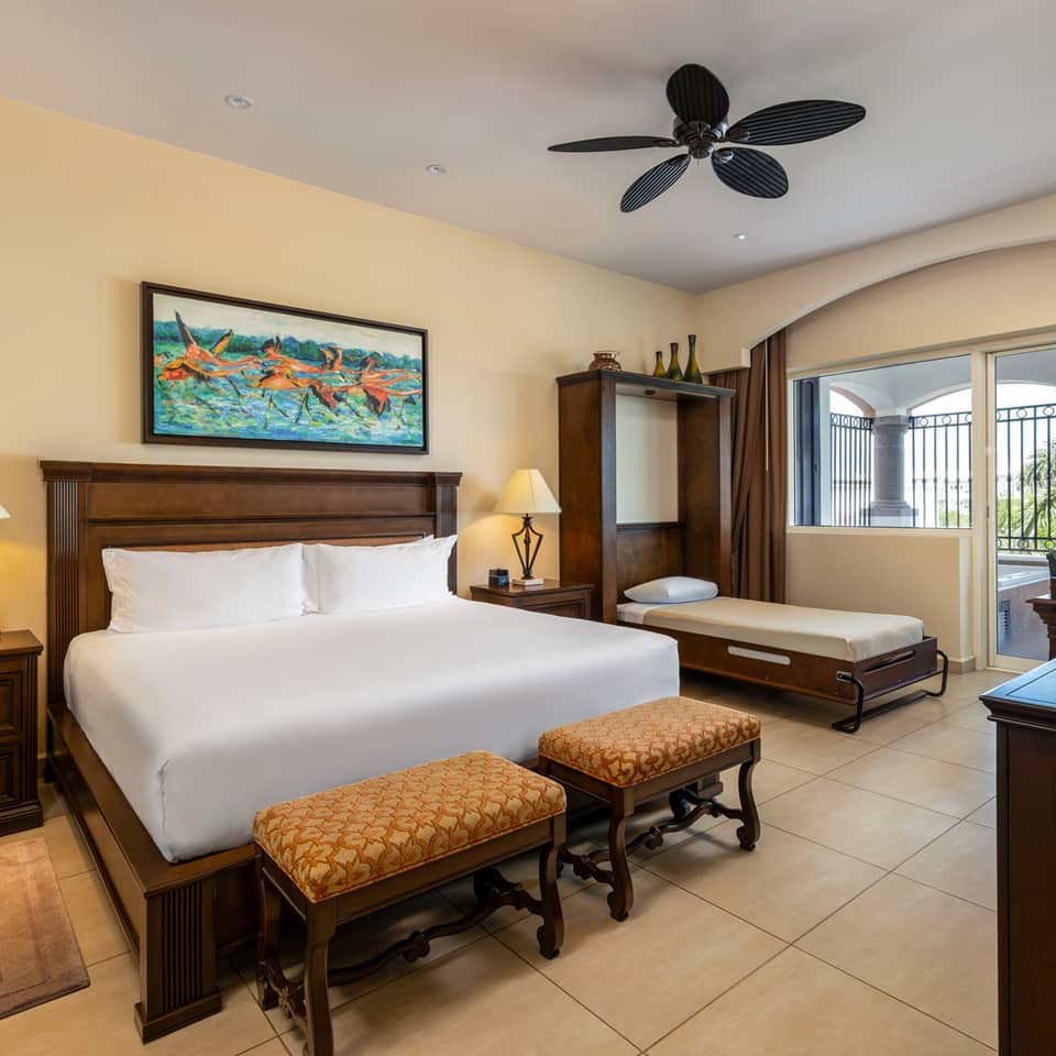 Spacious master bedroom with king bed, daybed, and balcony.