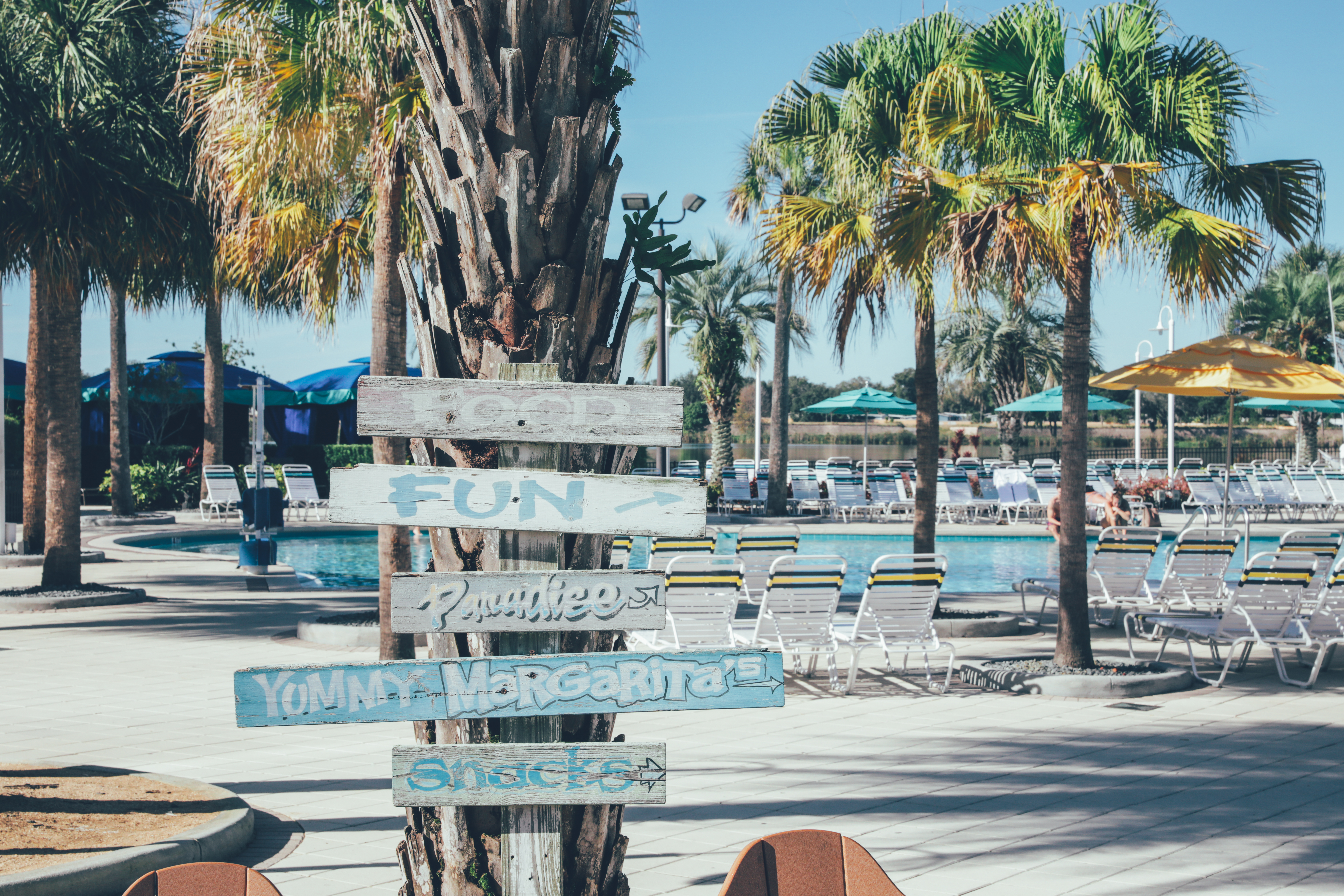 Property signage with pool and palm trees in background in the West Village at Orange Lake Resort near Orlando, Florida.