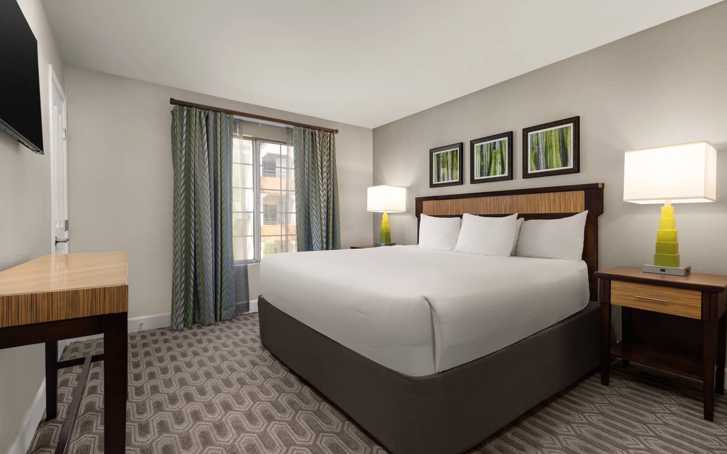Bright, modern bedroom featuring a plush king bed and warm accents.