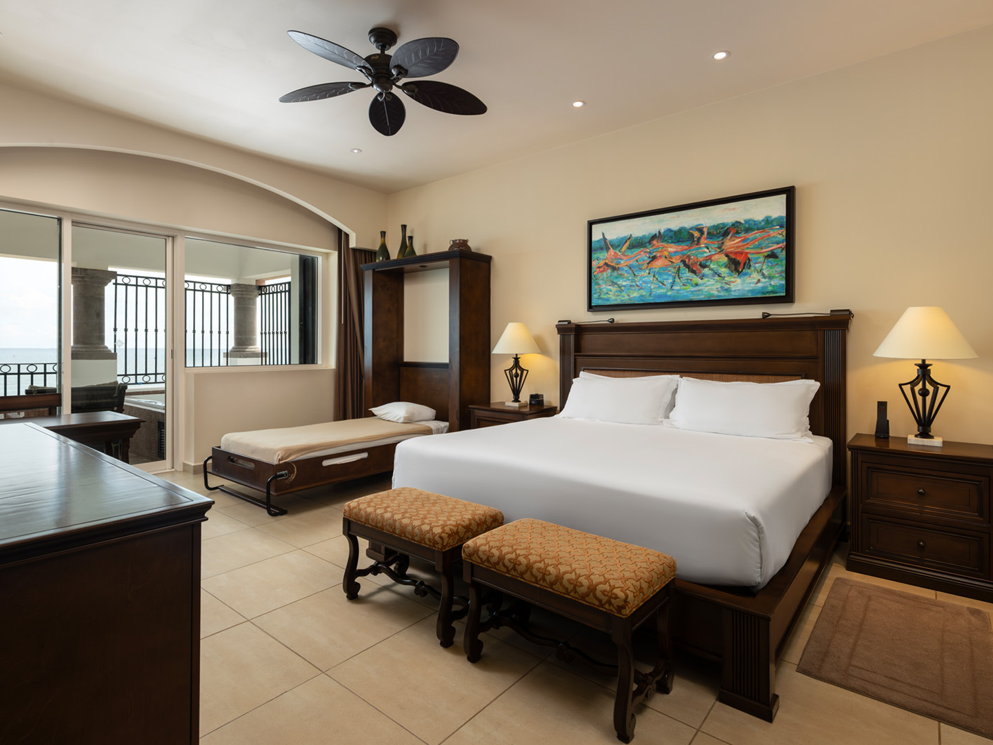 Beachfront suite bedroom with king bed, daybed, and ocean views.