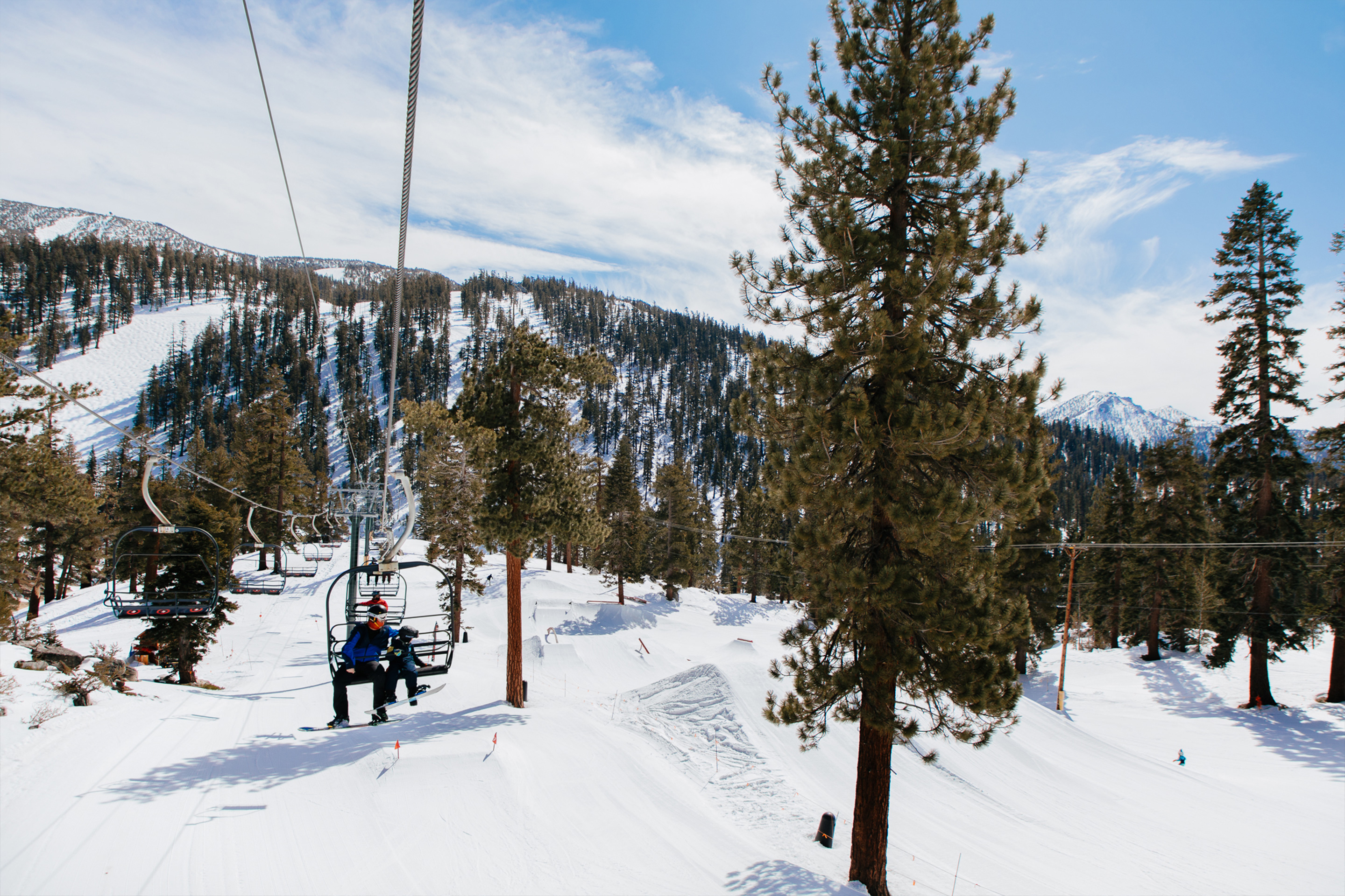 The chair lift at our Tahoe Ridge resort with two guests in ski gear.