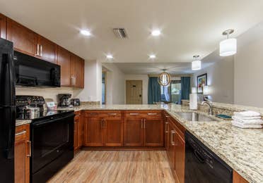 Full kitchen with refrigerator, microwave, stove, dishwasher, and sink in a two-bedroom villa at Scottsdale Resort