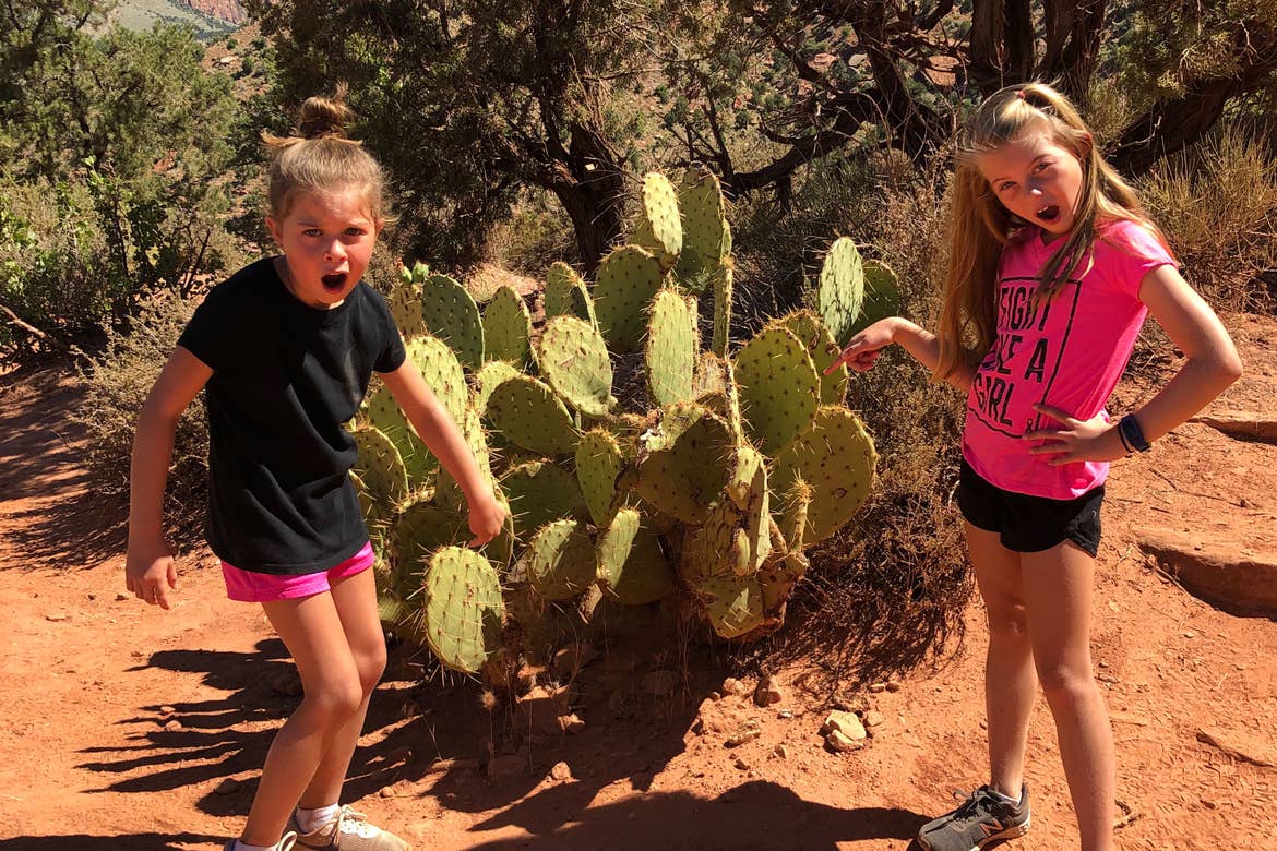 Kyler (left) and Kyndall (right) pose in front of a cacti at Zion National Park.