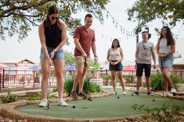 Friends playing mini golf at Hill Country Resort in Canyon Lake, Texas.