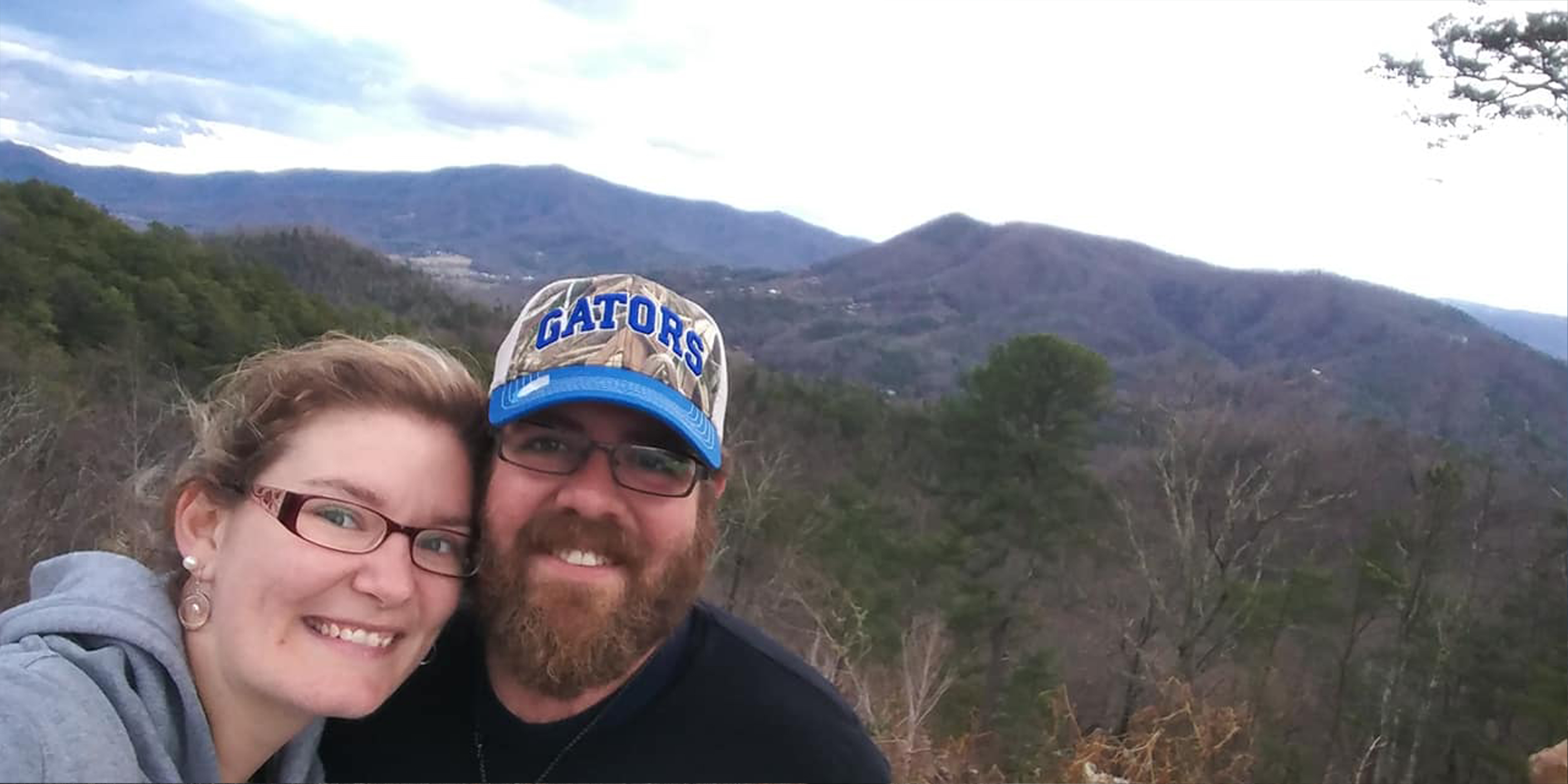 Becca and her husband taking a selfie in front of the mountains