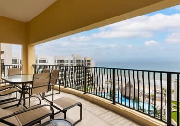 Spacious oceanview balcony with loungers and dining set.