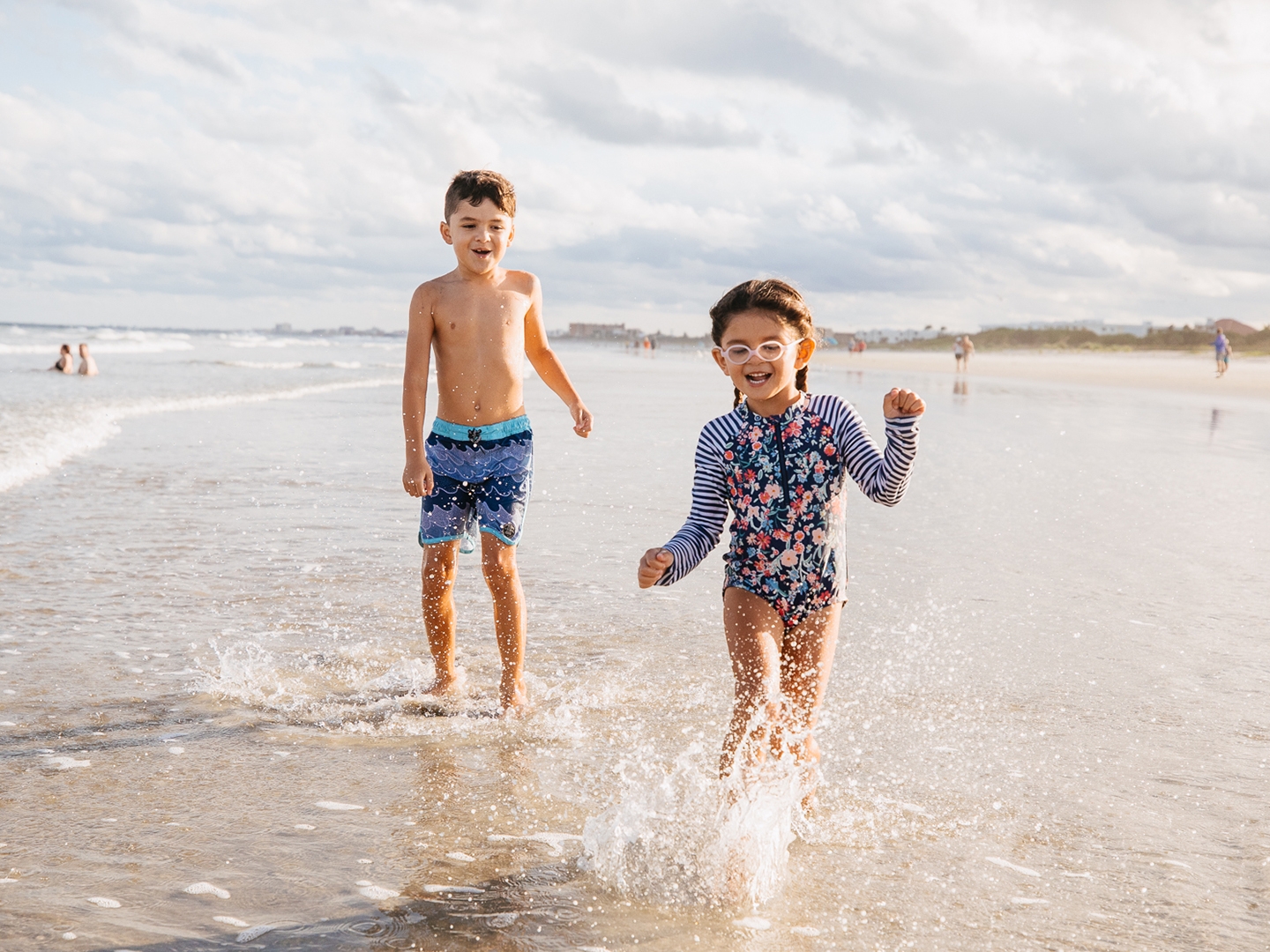 Two children running on beach near Cape Canaveral Beach Resort in Florida.