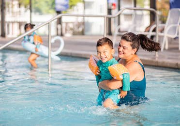 Adult and child playing in pool at Holiday Hills Resort in Branson, Missouri.