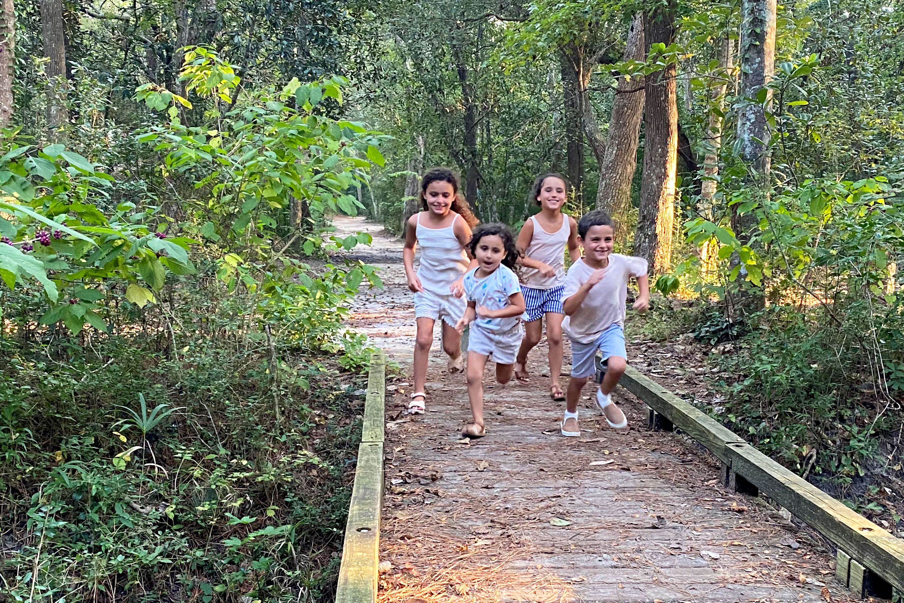 Brenda's kids run on the hiking trail through a lush landscape.