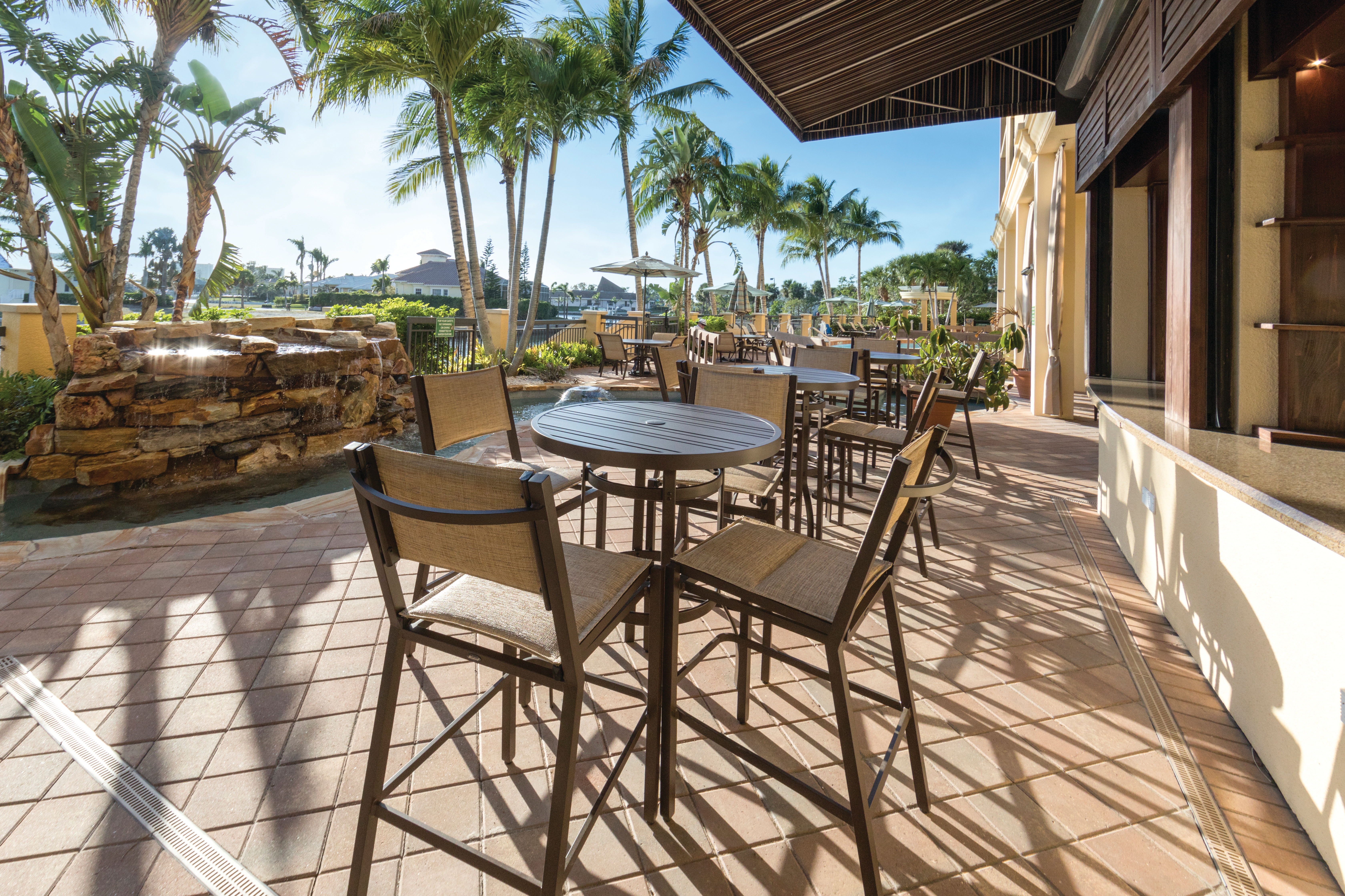 Outdoor seating surrounded by palm trees at Sunset Cove Resort in Marco Island, Florida.