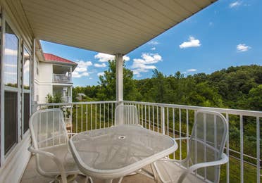 Balcony with table and chairs in a two-bedroom ambassador villa at the Holiday Hills Resort in Branson Missouri.