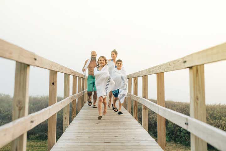 Family running on beach pier