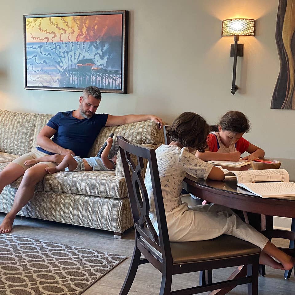 Brenda's family sits in their villa with work and play.