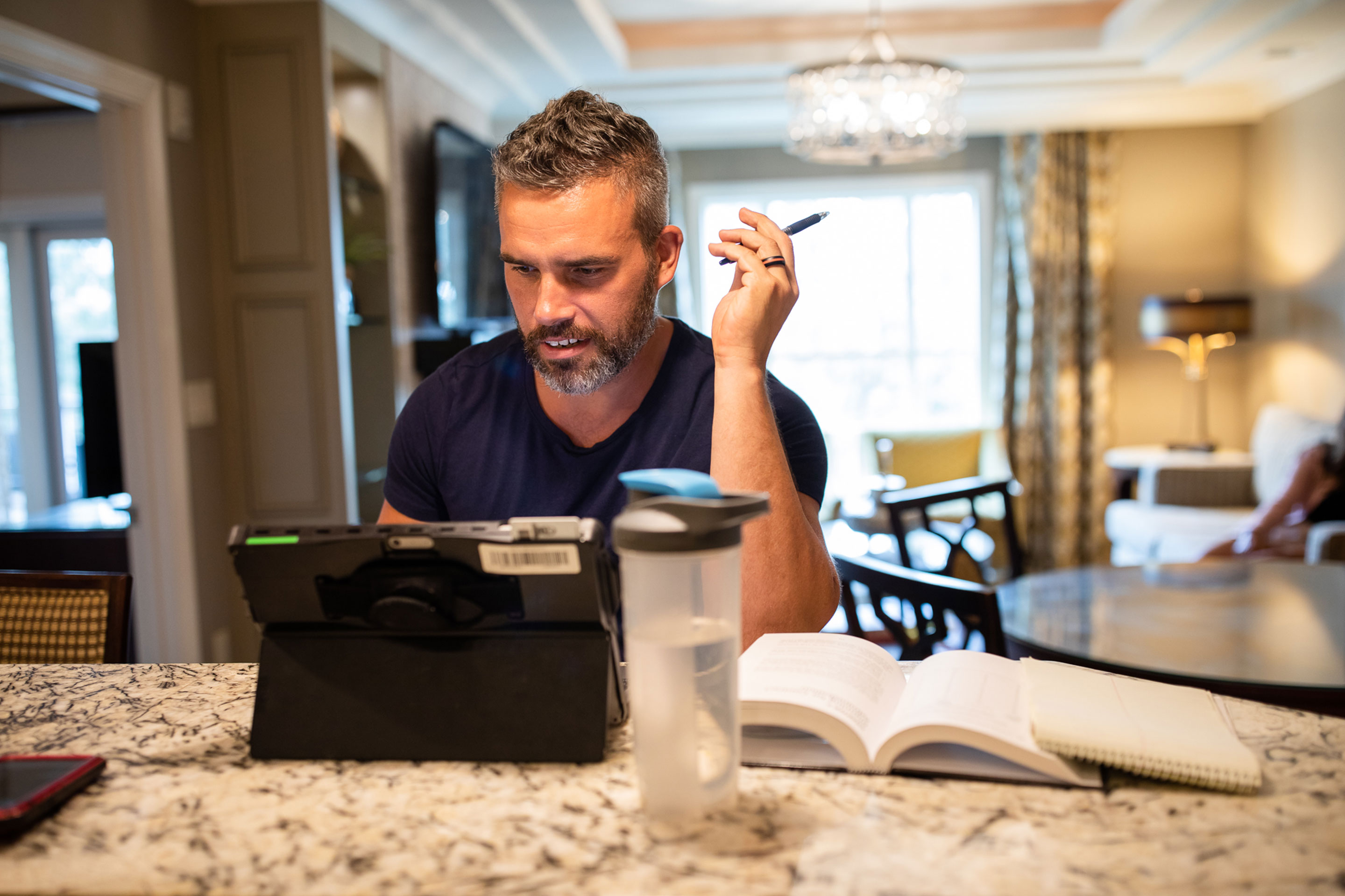 Brenda's husband, Isaiah, sits at the kitchen countertop with his laptop as he works remotely.