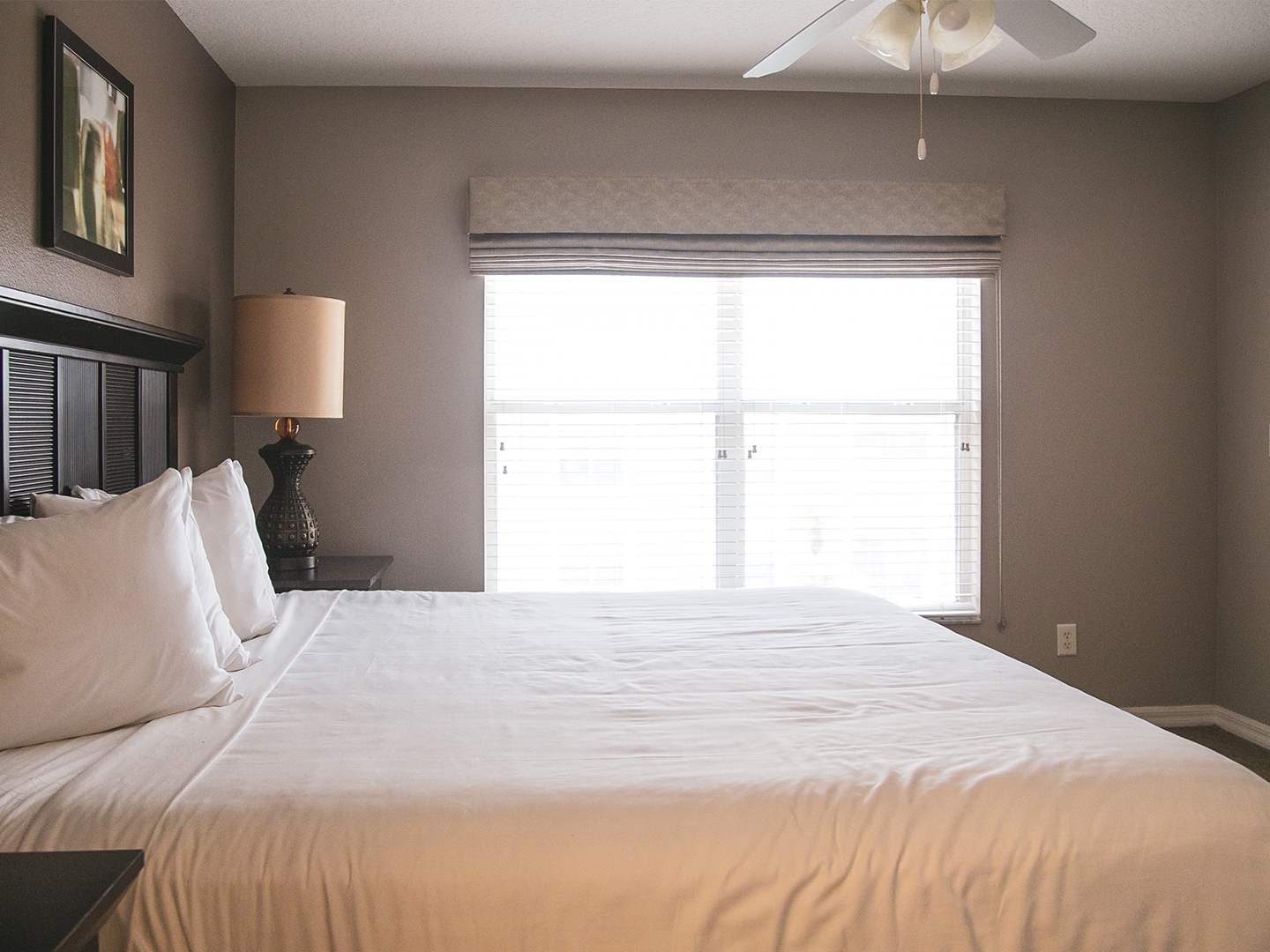 Bedroom with bed, ceiling fan and window in a villa at Orlando Breeze Resort.