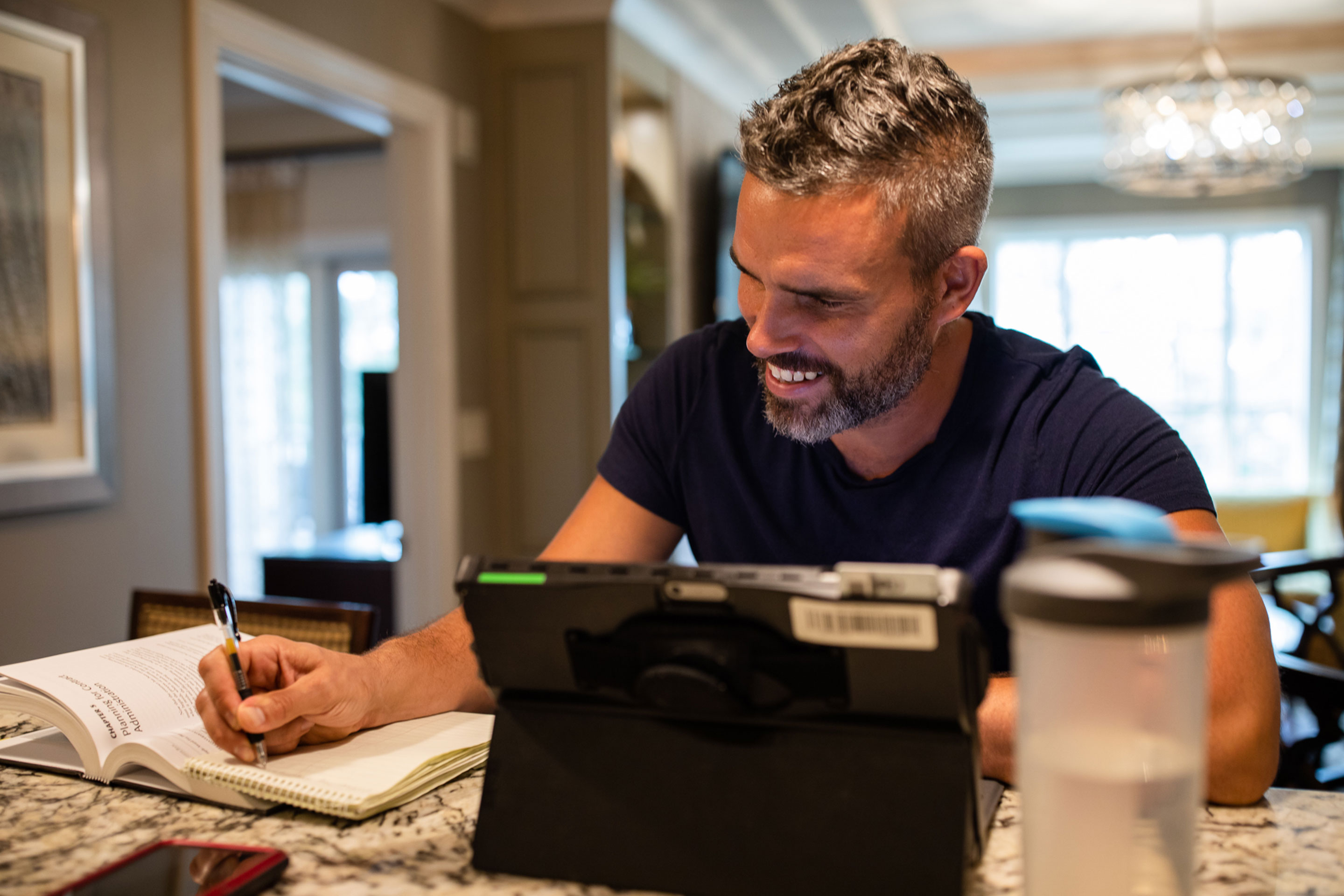 Brenda's husband, Isaiah, sits at the kitchen countertop with his laptop as he works remotely.
