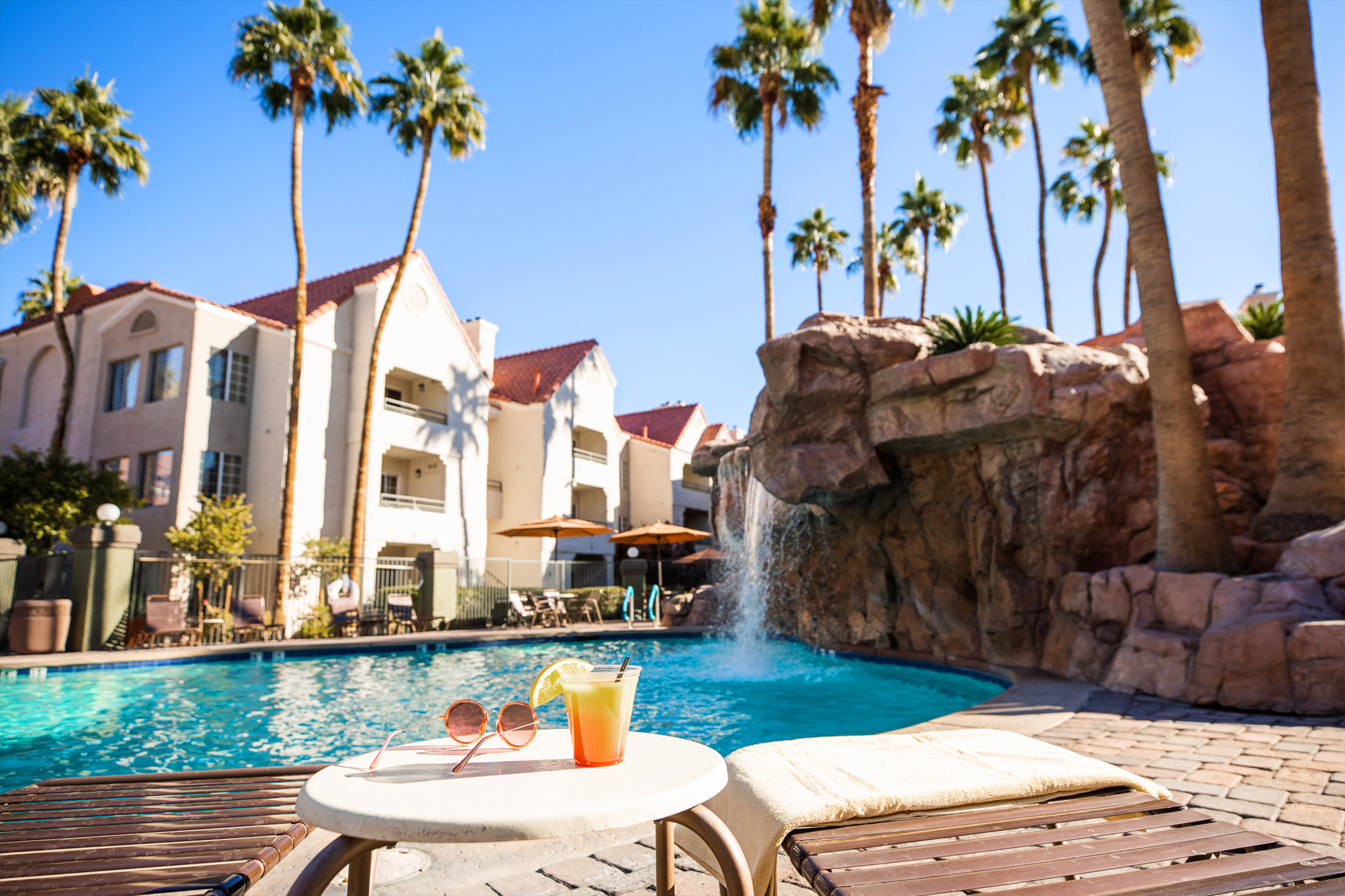 Drink by waterfall pool at Desert Club Resort in Las Vegas, Nevada.