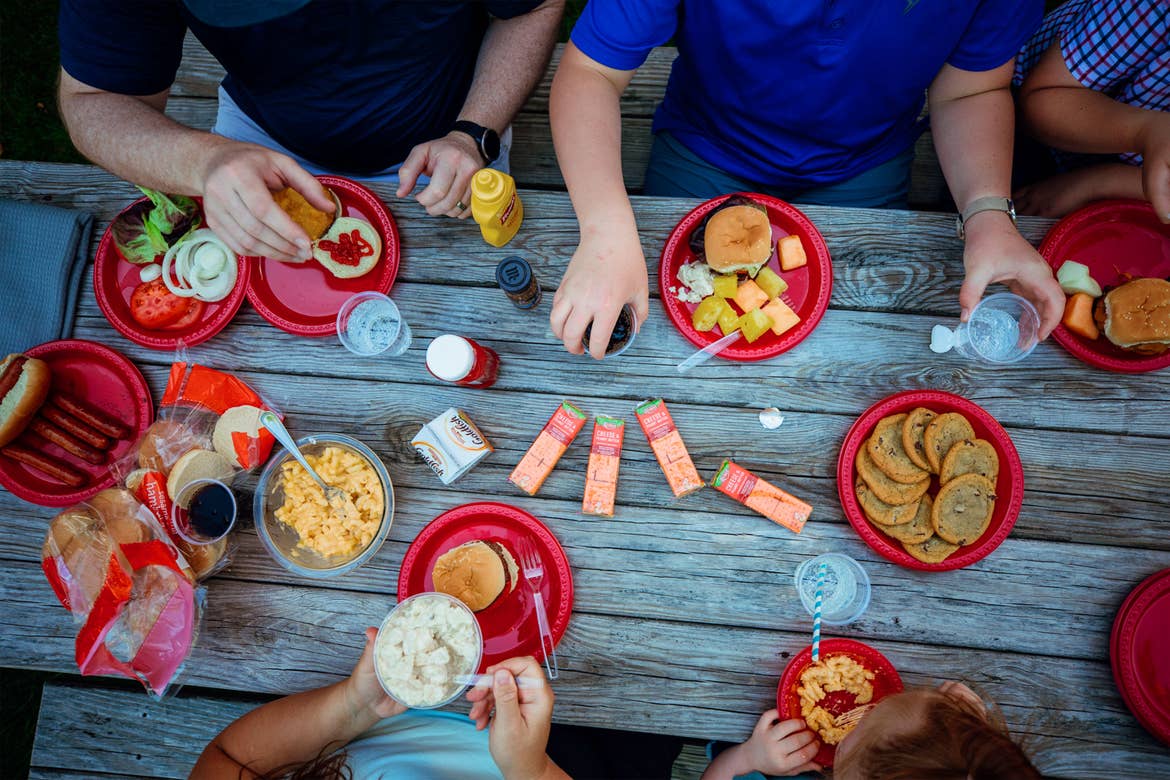 An overhead view of a picnic table with various food and snacks.