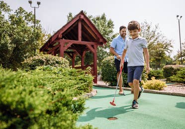Dad and son playing mini golf at Fox River Resort in Sheridan, Illinois.