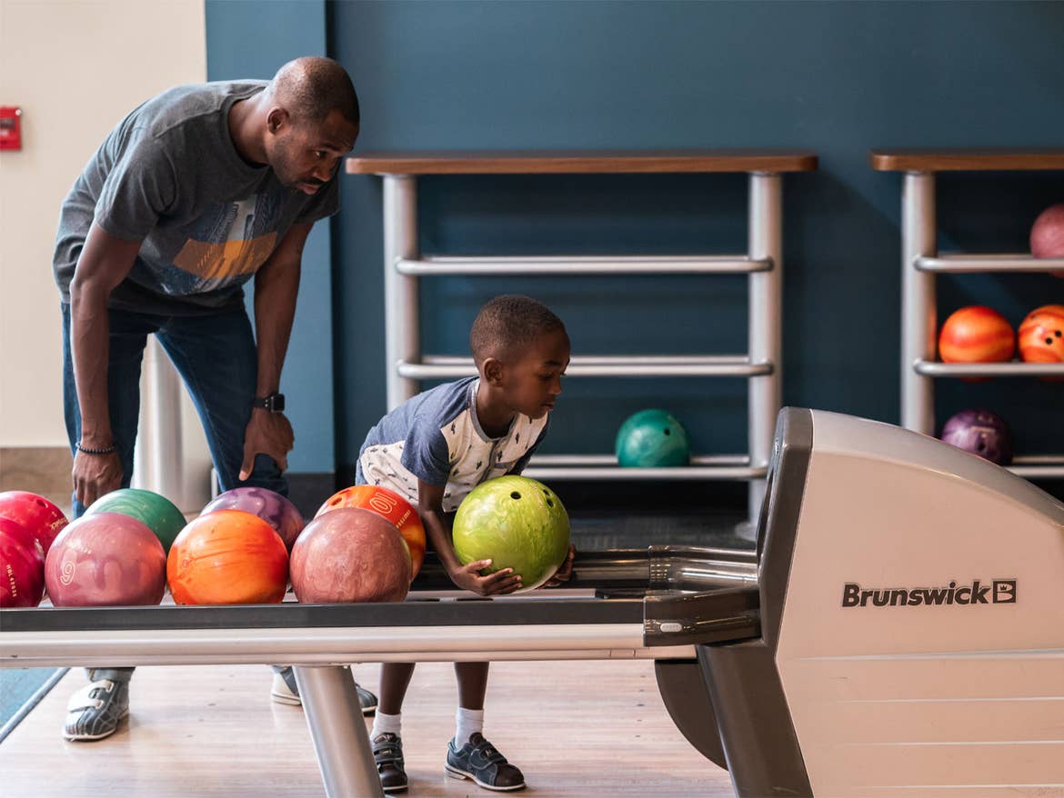 Adult and child bowling at Williamsburg Resort.