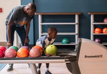 Adult and child bowling at Williamsburg Resort in Virginia.