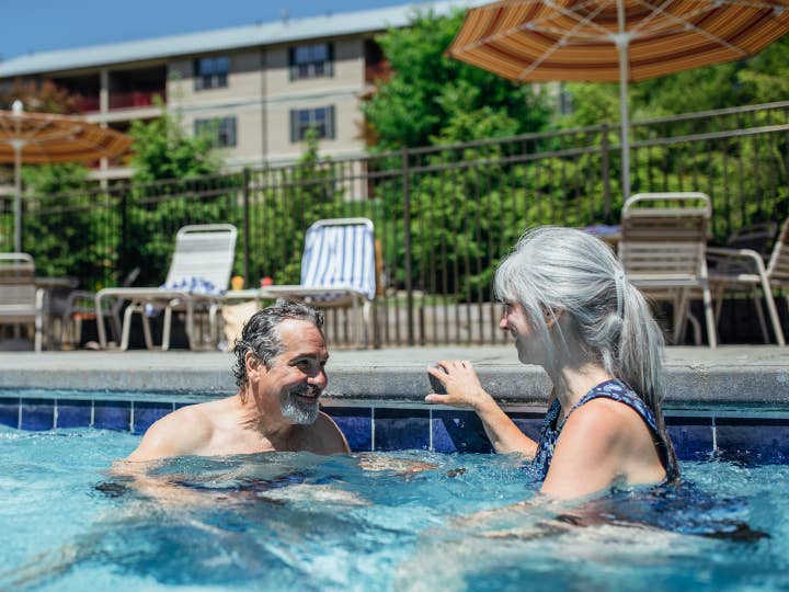 Couple sitting in outdoor pool at Oak n' Spruce Resort in South Lee, Massachusetts.
