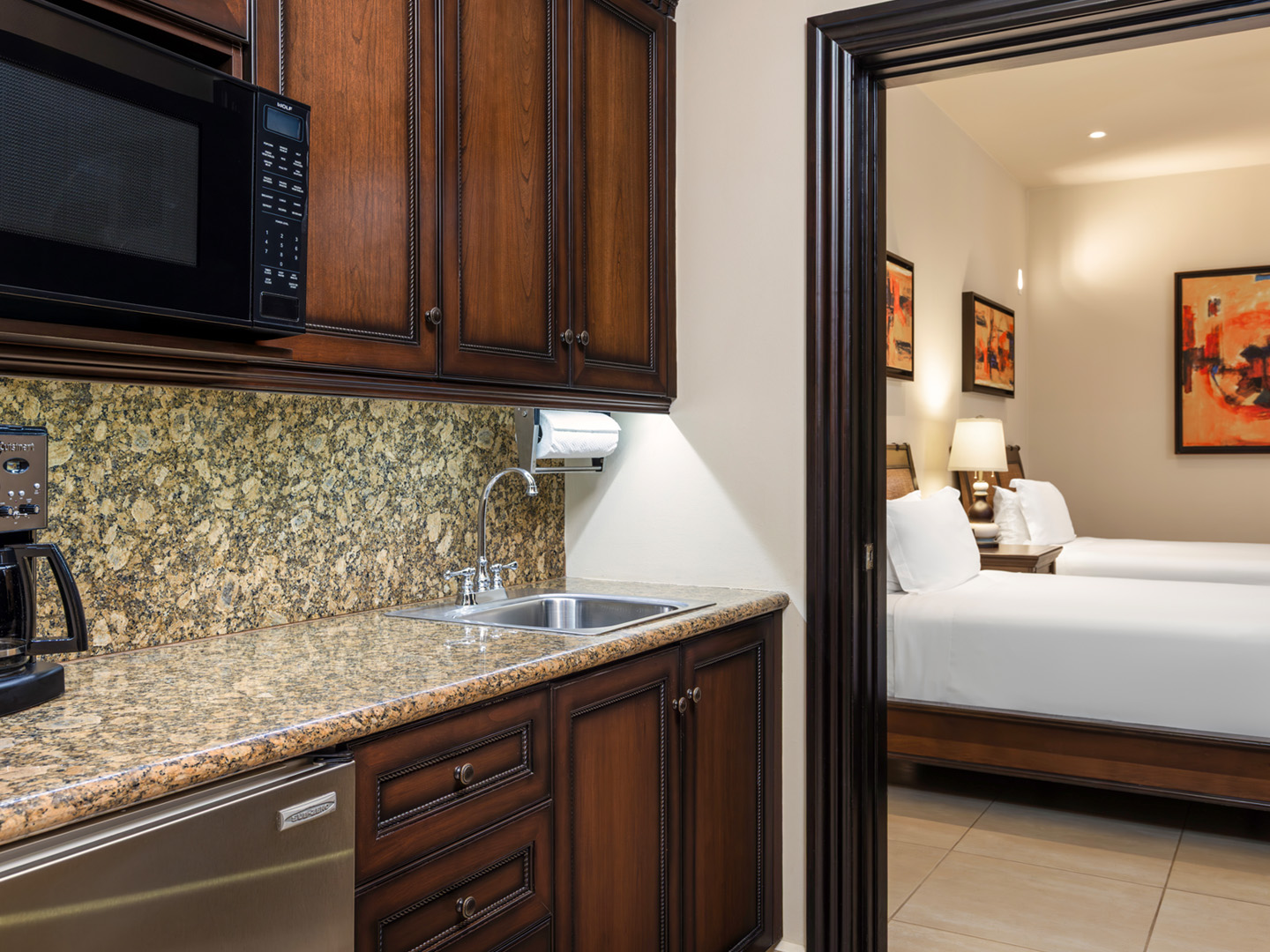 Kitchenette with granite counters leading into a double bedroom.