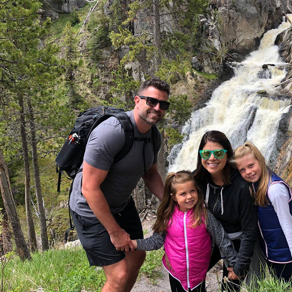 Author, Chris Johnston (middle-right), stands in front of the Mystic Falls at Yellowstone National Park with her husband, Josh (far-left), and daughters, Kyndall (far-right), and Kyler (middle-left).