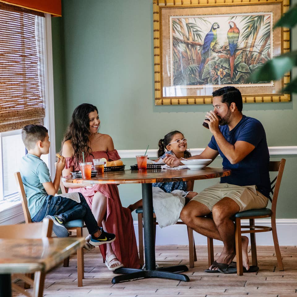 Family of four eating at Cape Grill & Bar at Cape Canaveral Beach Resort in Florida.