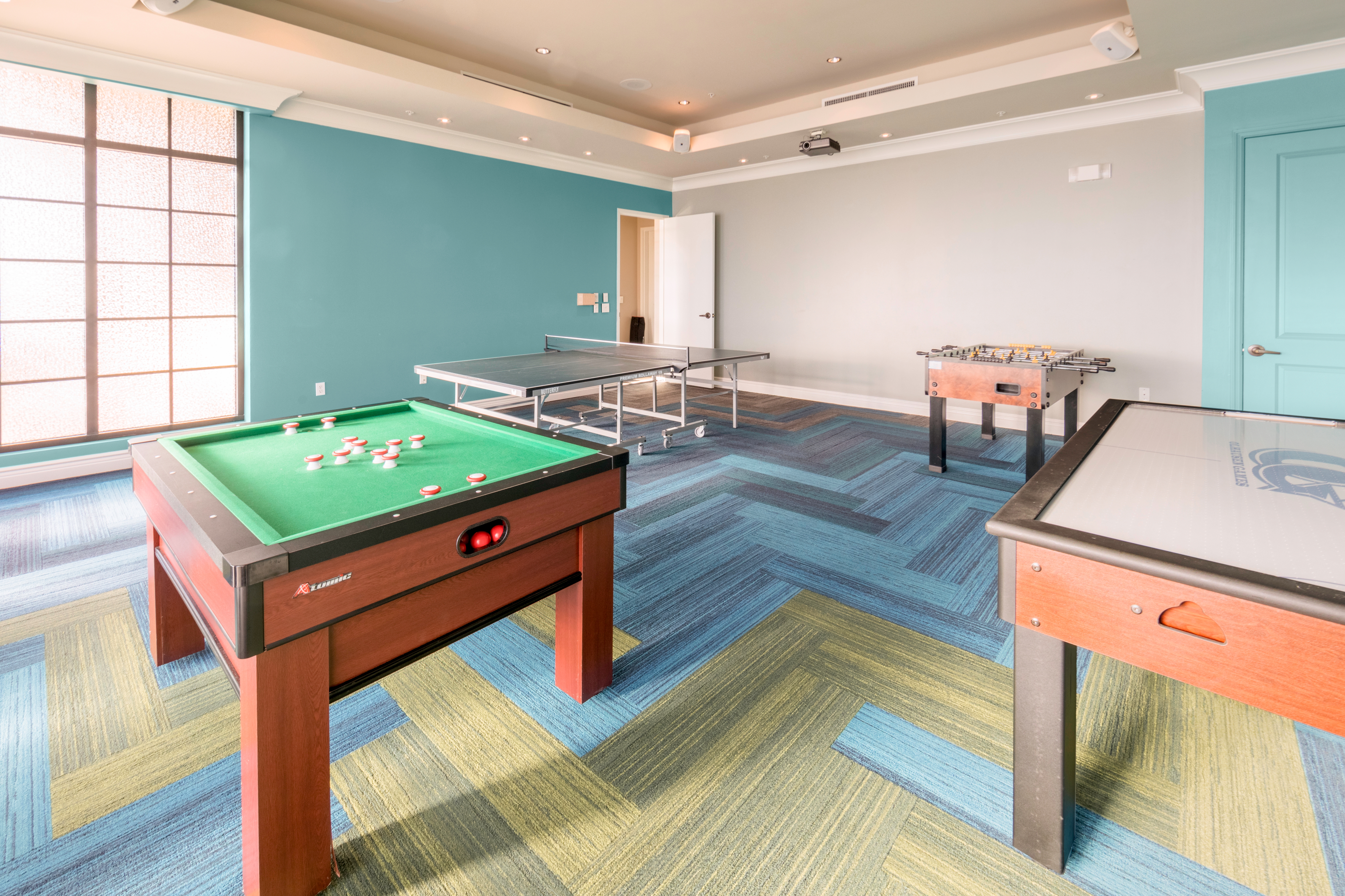 Game room with air hockey, Foosball, and ping pong tables at Sunset Cove Resort in Marco Island, Florida.