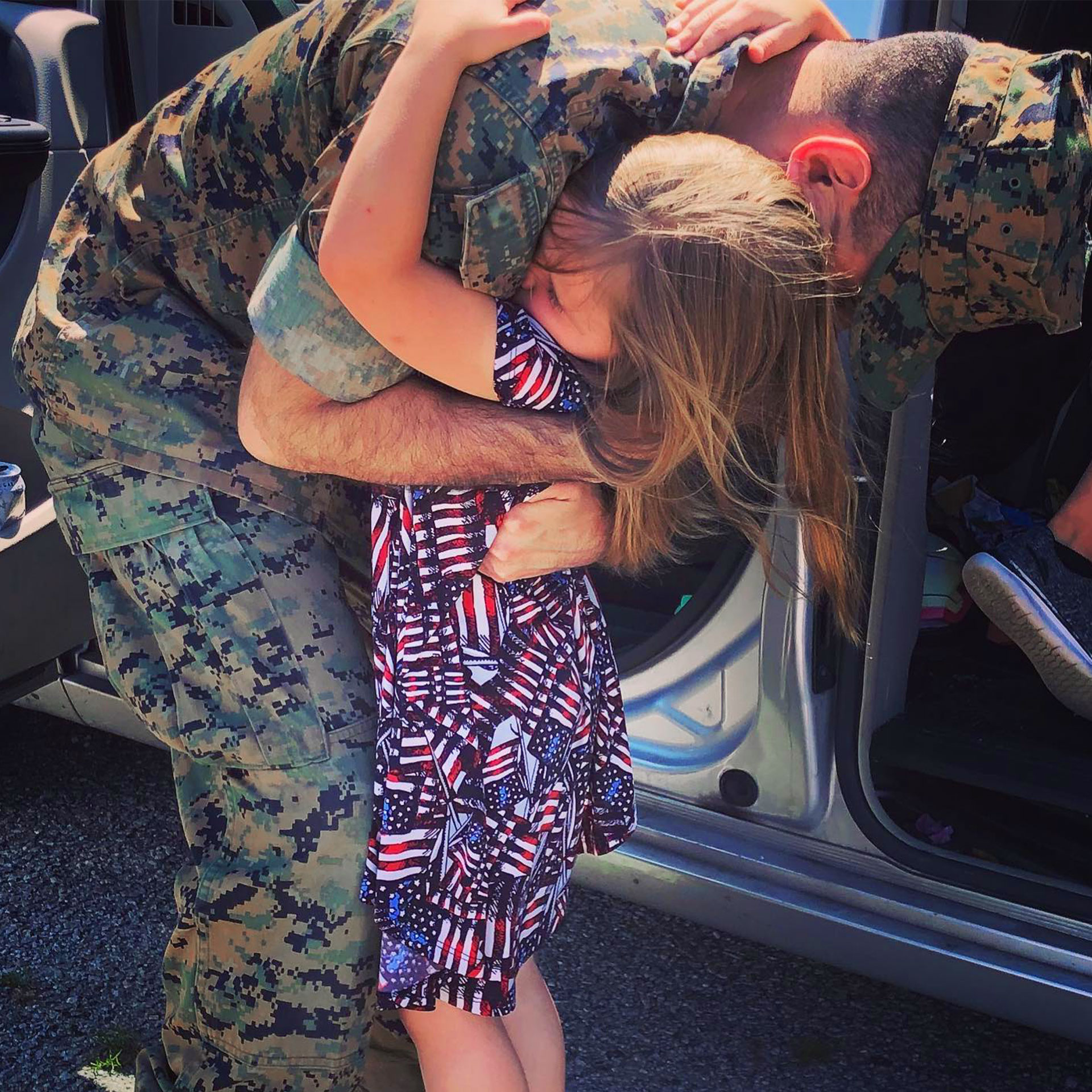 Sara Perezes youngest daughter (right) is held by her dad in his uniform as he leaves for deployment.