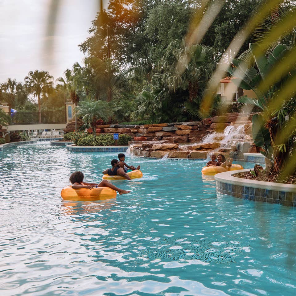 Family floating in orange tubes in lazy river at Orange Lake Resort near Orlando, Florida.