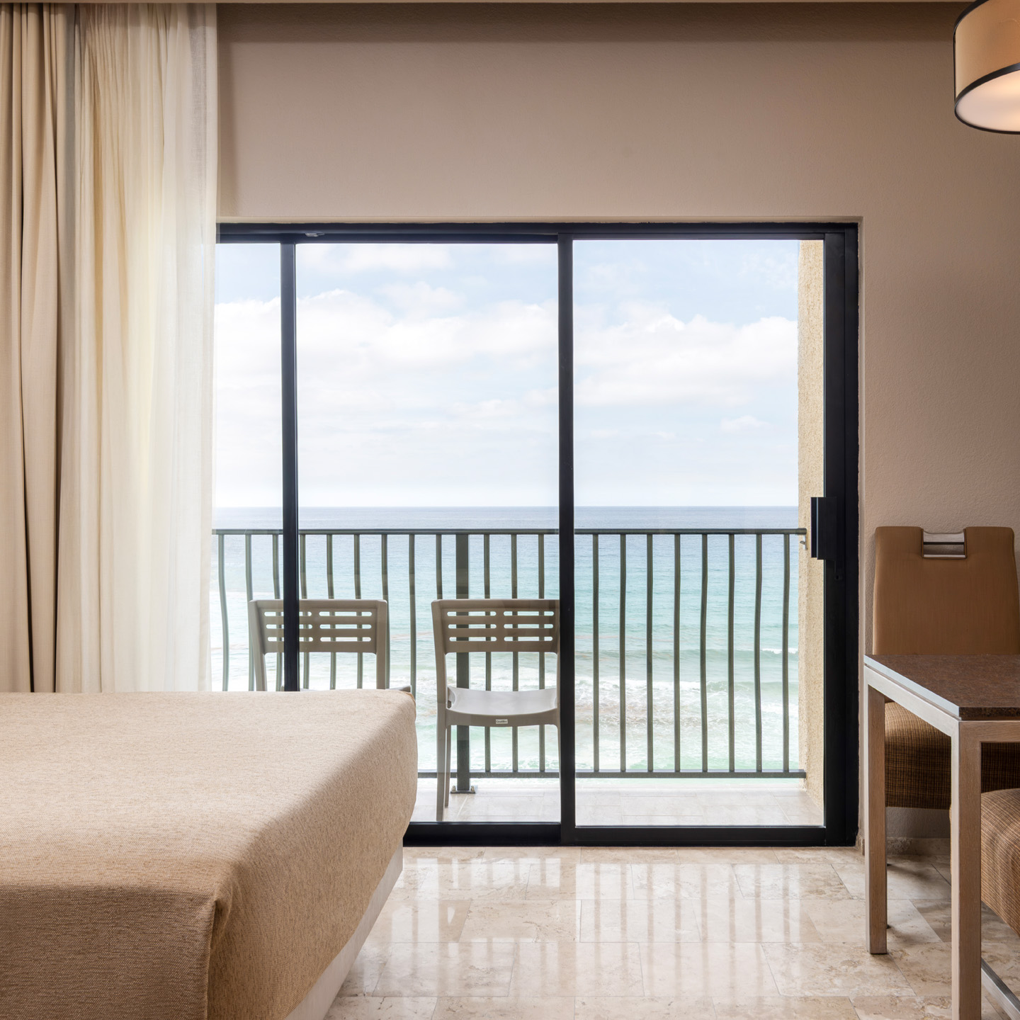 Oceanview living room with a Murphy bed, dining area, and balcony.
