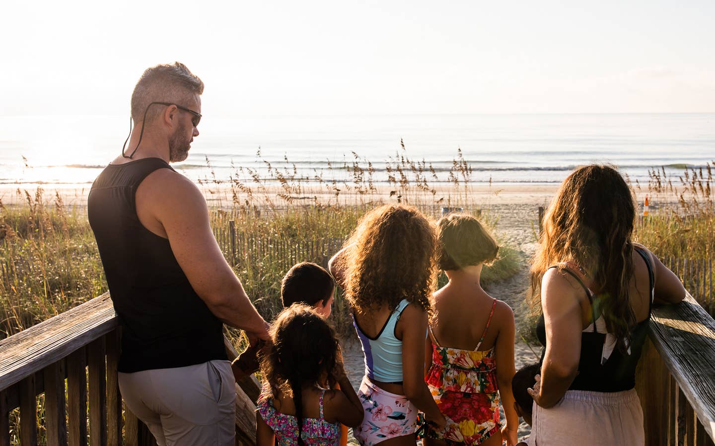 Author, Brenda Rivera Sterns' family stands facing the sunrise along the beach near our South Beach Resort in Myrtle Beach, South Carolina.