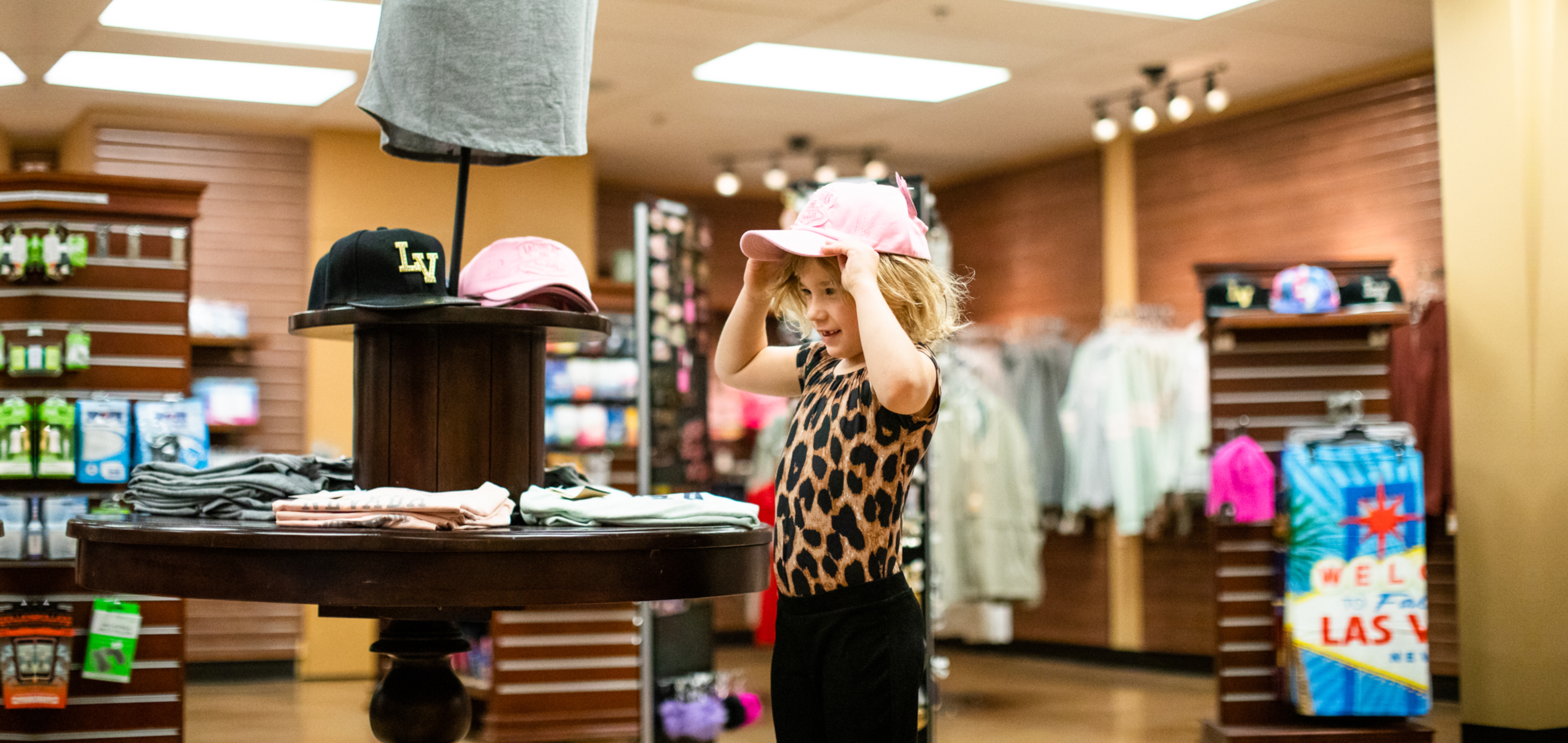 Young child trying on a Las Vegas hat in Marketplace at Desert Club Resort in Las Vegas, Nevada.