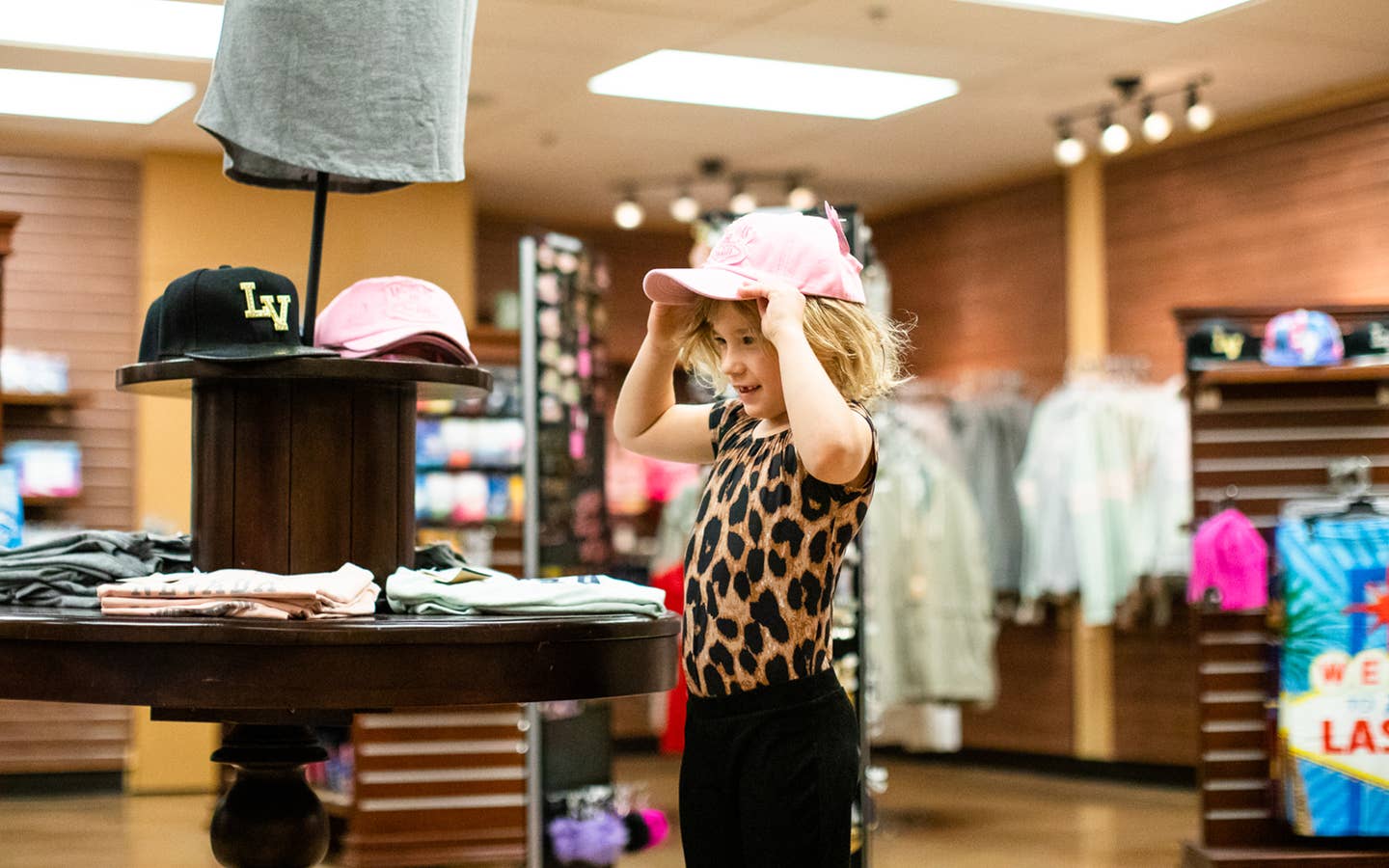 Young child trying on a Las Vegas hat in Marketplace at Desert Club Resort in Las Vegas, Nevada.