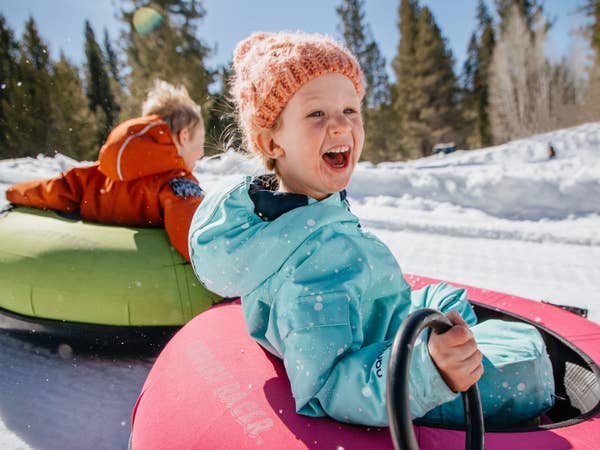 Two children snow tubing down mountain near Tahoe Ridge Resort in Stateline, Nevada.