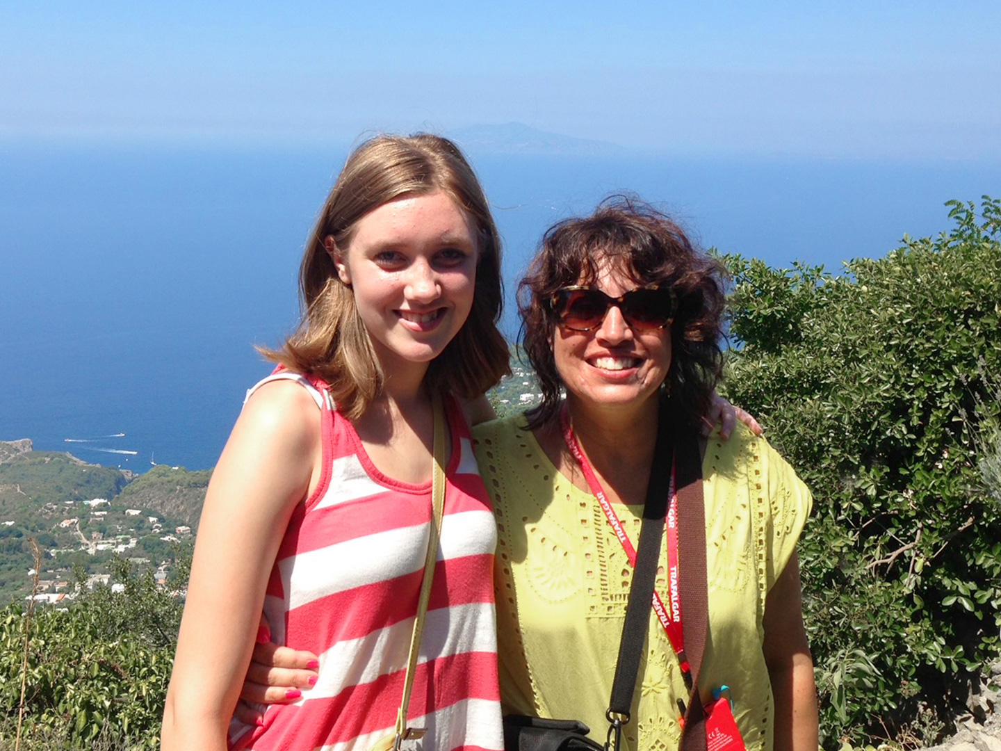 Featured Author, Jennifer Probst (right) stands with her niece (left) in front of a hill that overlooks the coastline of Italy.