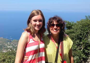 Featured Author, Jennifer Probst (right) stands with her niece (left) in front of a hill that overlooks the coastline of Italy.