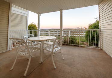 Furnished balcony with table and four chairs in a Presidential two-bedroom villa at Ozark Mountain Resort in Kimberling City, Missouri