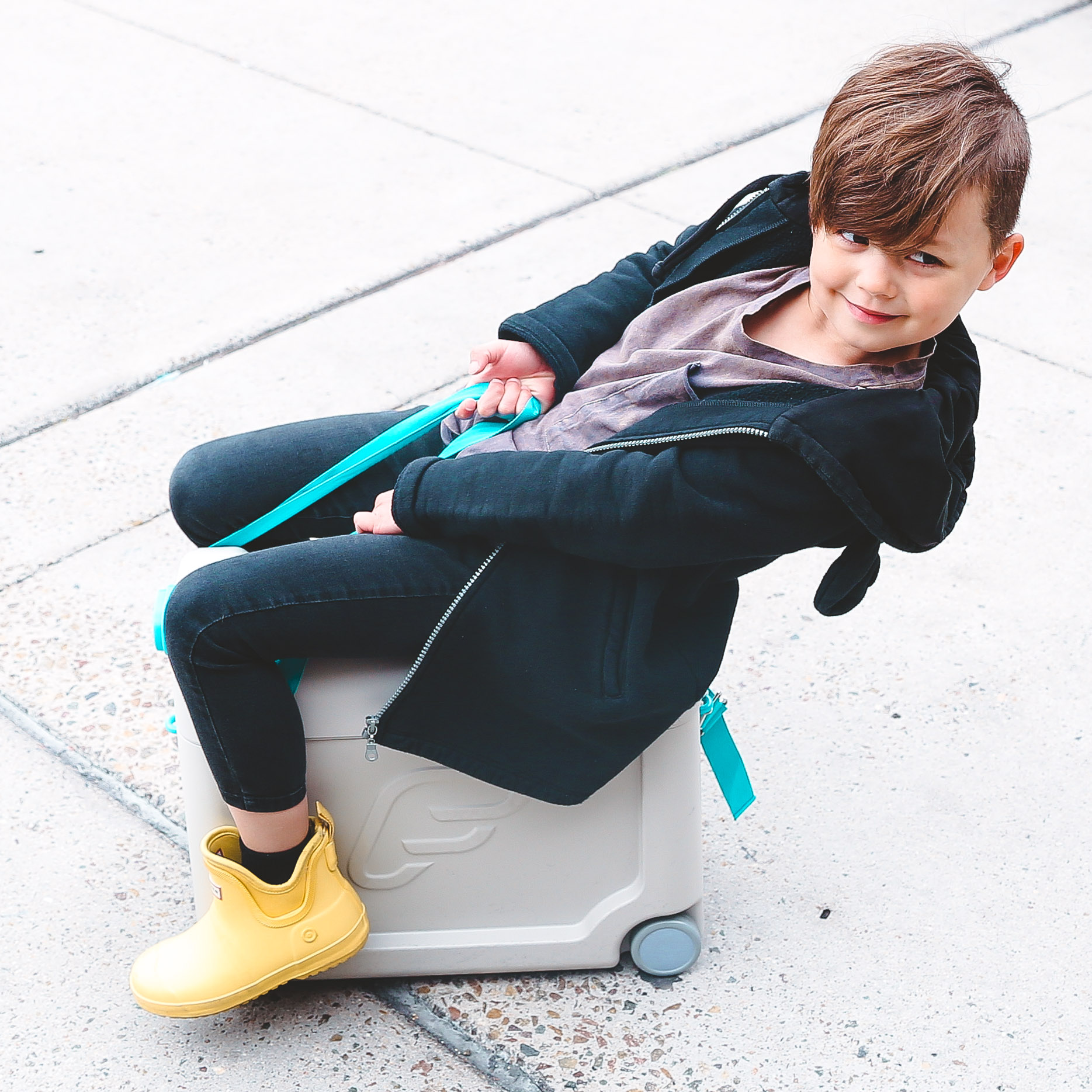 Mia's son sitting on suitcase