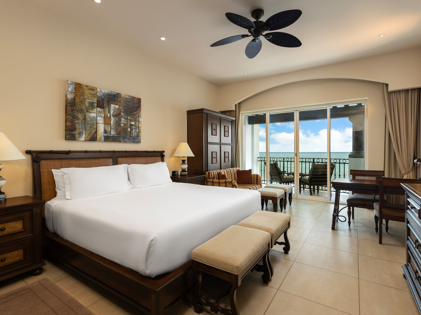Oceanview king bedroom with seating area, daybed, and balcony.