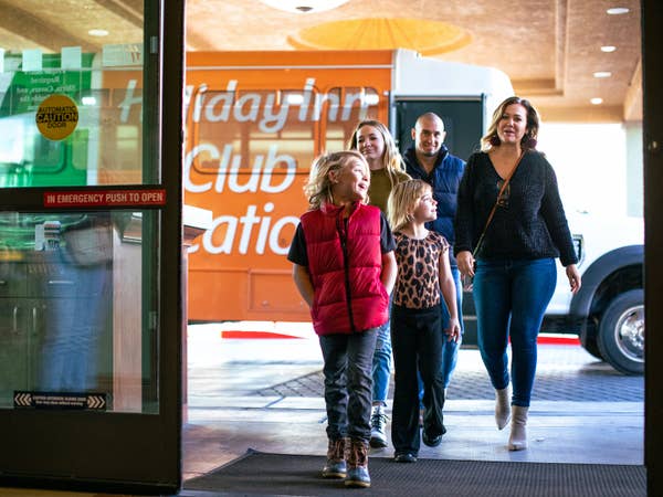 Family of five getting off resort shuttle at Desert Club Resort in Las Vegas, Nevada